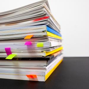 stack of notebooks tabbed with sticky notes.