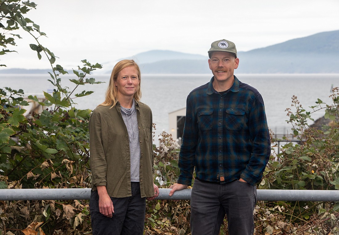 Western Washington University geophysics assistant professor Emily Roland, left, and geology professor Colin Amos posing in front of Bellingham Bay